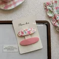 Haarklammern Set mit Blumenmuster und rosa Stoff auf Displaykarte mit sanftem Hintergrund - Oval Blumen Haarklammer