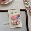 Gros plan de pinces à cheveux fleuries et à paillettes roses sur carte de support - Paillettes Ovales Et Pince Plissée