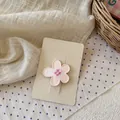 Primer plano de pinza para pelo con flor rosa y centro de cuadros sobre cartón ecológico - Pinza de Flor Rosa Pálido