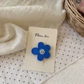 Vista detallada de una pinza de pelo de flor azul mate con centro floral en tarjeta - Pinza de Flor Azul Oscuro