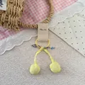 Detail of yellow cherry pom-pom hair tie with floral bow on a paper display card - Yellow Cherry Hair Tie
