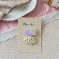 Gros plan de barrettes en tissu rose et violet avec fleur au crochet et motif à pois - Barrettes à Pois Blanc Cassé