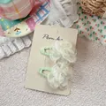 Detail of two white organza flower hair clips with green grosgrain ribbon wrapping - Beige Flower Hair Clip
