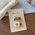 Detail of two cute embroidered bear and acorn hair clips on a display card - Bear and Chestnut Flower