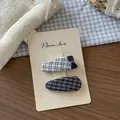 Dettaglio di due fermagli per capelli in tessuto a quadretti per bambina su cartoncino - Stile Plaid Goccia d'Acqua Marino