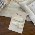 Détail de pinces à cheveux avec dentelle blanche et rayures jaunes sur carte support - Pince à Cheveux Dentelle Nœud Goutte