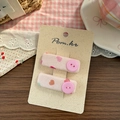 Détail de barrettes en tissu à motif cœur rose avec boutons sur carte de présentation - Style Bouton Rose Carré