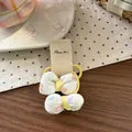 Dettaglio di due elastici per capelli in tessuto con pois colorati su sfondo legno - Fiocco Giallo