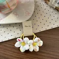 Dettaglio di elastici per capelli per bambini in tessuto floreale su un piatto di ceramica - Fiore Giallo