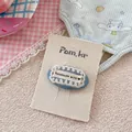 Dettaglio del fermaglio fatto a mano in denim blu con pizzo e etichetta a cuore - Lettere In Pizzo Denim
