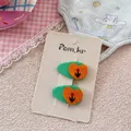Dettaglio di fermagli ricamati verdi con tulipani e cuori su un cartoncino beige logato - Coppia Fiori Cuore
