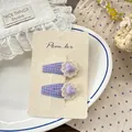 Detail of floral lace and plaid fabric hair clips set on a decorative ceramic plate - Purple Plaid Flower Hair Clip