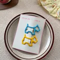 Primer plano de horquillas metálicas de perro en amarillo y azul sobre platillo - Azul + Amarillo