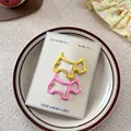 Gros plan de pinces à cheveux mignonnes en forme de chien en émail jaune et rose - Jaune+Rose