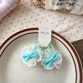 Détail de deux chouchous à nœud bleu avec maille de dentelle blanche sur assiette - Hortensia Vert Clair