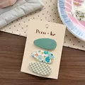 Set de tres pinzas de tela con flores y cuadros para niñas en cartón de venta - Floral Verde