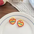 Dettaglio degli elastici per capelli a cuore ricamati in giallo su un piatto di porcellana - Stile Cuore