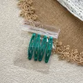 Close-up of four dark green teardrop metal hair clips in transparent packaging - Dark Green Style / Set of 4