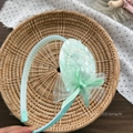 Detail view of mint green headband with non-slip teeth, tulle flower and satin bow - Hat Style Headband / Green