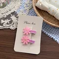 Détail de pinces à cheveux fleurs roses avec étamines jaunes et ruban à carreaux - Rose