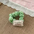 Dettaglio dell'elastico per capelli a quadretti verdi con patch a ciliegia dolce - Elastico Verde