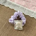 Close-up of purple plaid scrunchie with cute cartoon dog patch and happy text detail - Purple Scrunchie