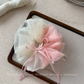 Détail d'un chouchou en maille rose et blanche avec perles et un nœud en ruban de soie doux - Rose
