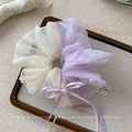 Détail d'un chouchou en maille violette avec perles blanches et élégant nœud en ruban - Violet