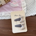Détail de deux barrettes à nœuds à carreaux de style coréen sur carte support - Pince à Cheveux Noeud Gris