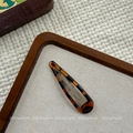 Macro shot of stylish tortoiseshell drop-shaped BB hair clip on textured fabric background - Large Waterdrop BB Clip (NK2084-1)