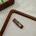 Detail of a rectangular tortoiseshell hair clip with premium acetate texture on a tray - Amber Square BB Clip (NK2084-3)