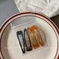 Close-up of four-piece vintage resin BB hair clips in amber and black marble finish - Mixed Yellowish Brown and Black