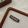 Detailed close-up of tortoise shell resin hair clip on a vintage wooden tray - Black Leopard Square BB Clip (NK2084-4)