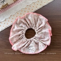 Detailansicht eines rosa geblümten Haargummis mit feiner Stickerei und Pom·kr Label - Rosa Geblümtes Haargummi