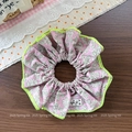 Blumen-Haargummi mit rosa Mustern und neongrünen Kanten auf Holzgrundlage - Helllila Blumen