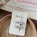 Detail of sweet blue embroidered heart hair clips set on a beige display card - Blue Green Heart Embroidered Hair Clip