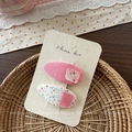 Dettaglio di due fermagli per capelli in tessuto floreale rosa per bambine su carta - Stile Toppa in Tessuto Rosa Goccia d'Acqua