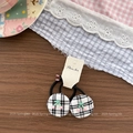 Detail of checkered hair ties with 3D cherry decor on vintage dark wood background - Black Plaid Hair Ties