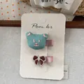 Detail of embroidered bear and brown bow hair clips on premium card display - Green Bear (Fully Covered)