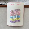 Close-up of 12-piece colorful patterned BB hair clips on white card display - Pink Series