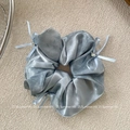 Dettaglio dello scrunchie in raso grigio-blu con fiocchi delicati e gemme scintillanti - Scrunchie Fiocco Blu