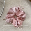 Dettaglio macro dello scrunchie in seta rosa con fiocchi di cristallo e raso lucido - Scrunchie Fiocco Rosa