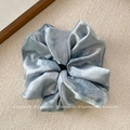 Detail of light blue satin scrunchie with wrinkled texture on beige background - Blue Large Scrunchie