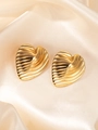 Macro shot of gold heart earrings with textured wavy patterns on champagne silk fabric - Striped Heart Earrings