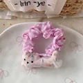 Detail eines rosa karierten Haargummis mit süßer Katze und Netzschleife auf Porzellanplatte - Rosa Katze Haargummi
