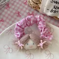 Détail du chouchou à carreaux roses avec une tête de poupée faite main et cheveux en laine - Rose