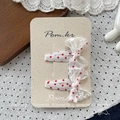 Détail de pinces à cheveux à pois rouges avec nœud en dentelle sur une carte de présentation - Barrette à Nœud en Dentelle à Pois