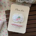 Detailansicht der Haarspangen mit Kirschstickerei und Spitze auf einer Markenkarte - Rosa Kirsche Spitze Clip