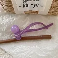 Detail of purple matte resin banana hair clip with golden logo and round bead decoration - Purple