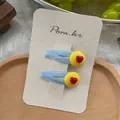 Detail of blue fabric hair clip with yellow round accent and red heart on paper card - Yellow Heart Style